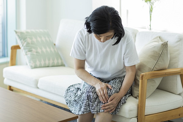 膝を抑える高齢の女性