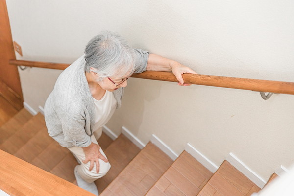 階段をあがる高齢の女性